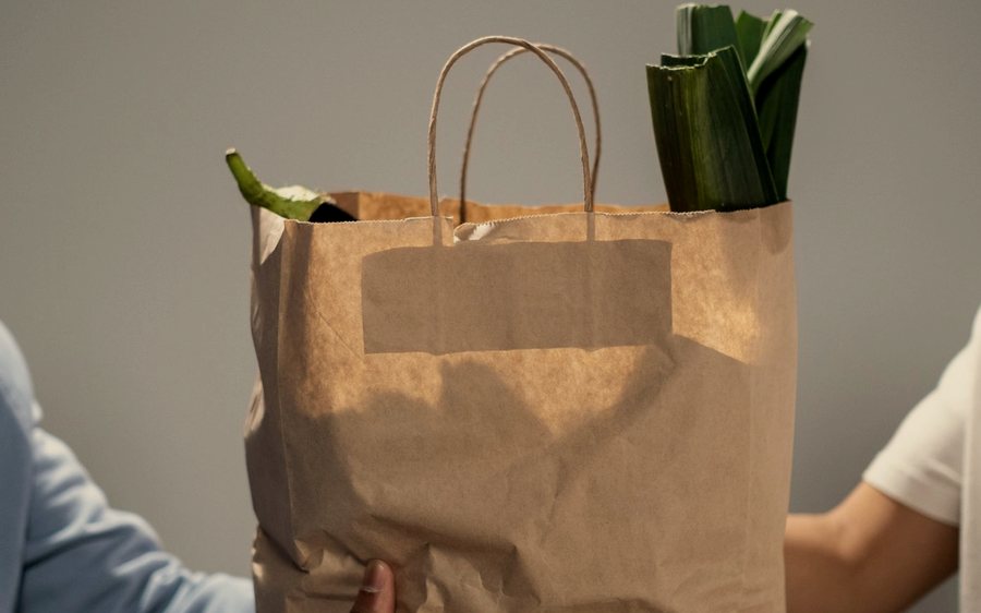 Un sac de courses passé de main en main.