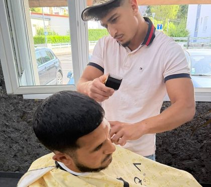 Un coiffeur terminant une coupe.
