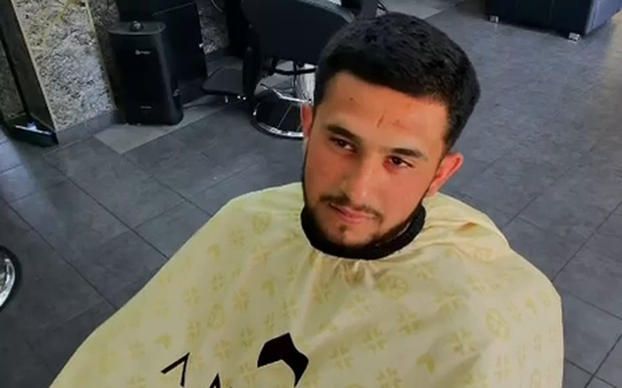 Un homme installé dans le fauteuil d&rsquo;un barbier partenaire.